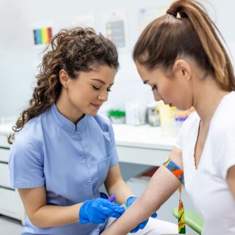 Medic și pacientă care efectuează o recoltare de sânge pentru analize